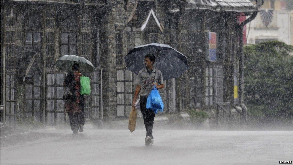 People hold umbrellas as they walk in a heavy rain shower in the northern Indian hill town of Shimla June 6, 2013. I