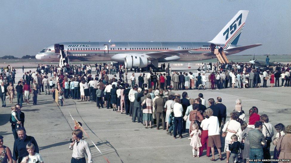 Passengers queue to get on a Boeing 757