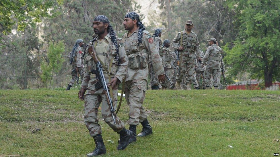 Pakistani troops at the scene of a blaze which gutted a historical building in Ziarat, south-east of Quetta, on 15 June