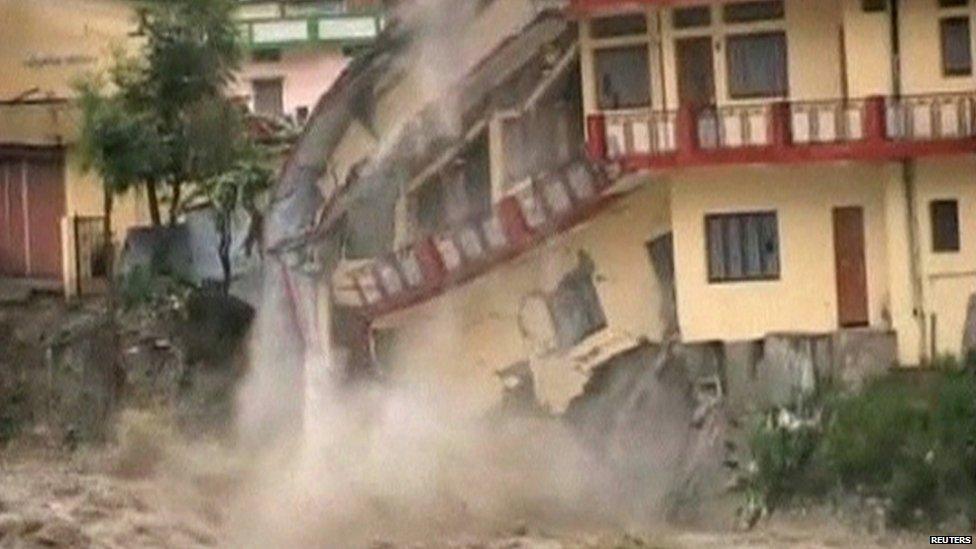 A building starts to collapse into rising water of river Ganga in northern India's pilgrimage town of Uttarkashi in this still image taken from video June 16, 2013, after 36 hours of rain