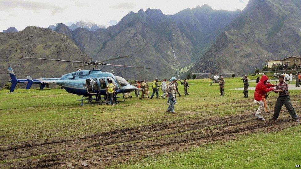 Rescuers help escort stranded pilgrims to helicopters to evacuate at Joshimath in the northern Indian state of Uttarakhand, India, Wednesday, June 19, 2013