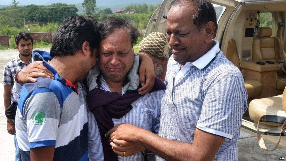 Indian pilgrims that were evacuated from a flood hit area by helicopter hug family members after arriving in Dehradun, the capital of the state of Uttarakhand on July 19, 2013.