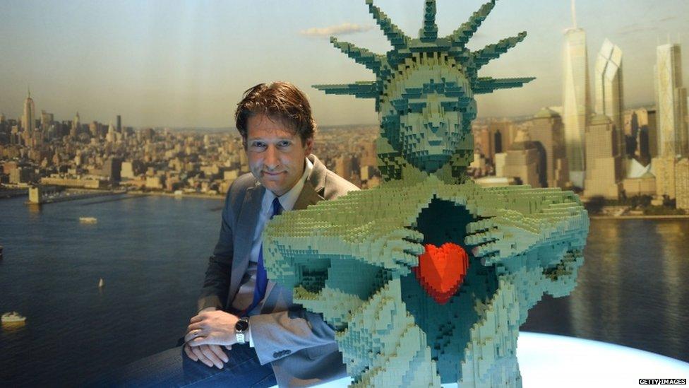 Artist Nathan Sawaya poses with one of his many Lego creations. This one is based on the Statue of Liberty.