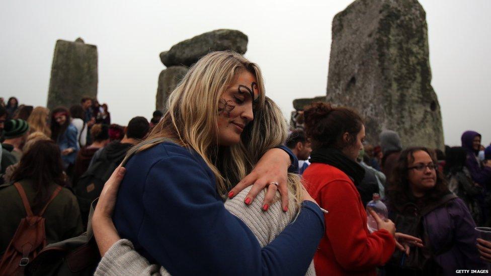 Revellers hug and cheer to mark the sunrise