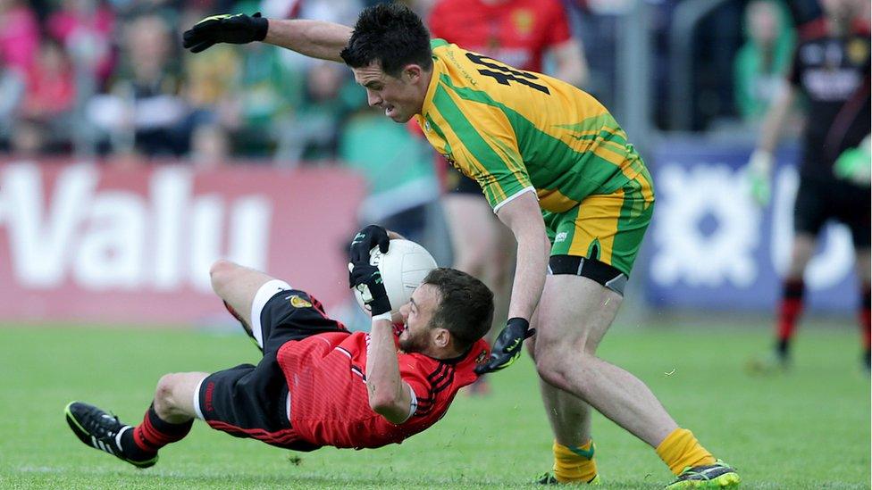 Conor Laverty of Down falls as David Walsh of Donegal attempts to win possession at Breffni Park