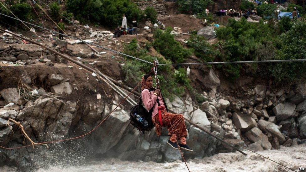 A stranded Indian pilgrim is transported across a river using a rope rescue system by Indo-Tibetan Border Police (ITBP) personnel in Govind Ghat on 23 June 2013