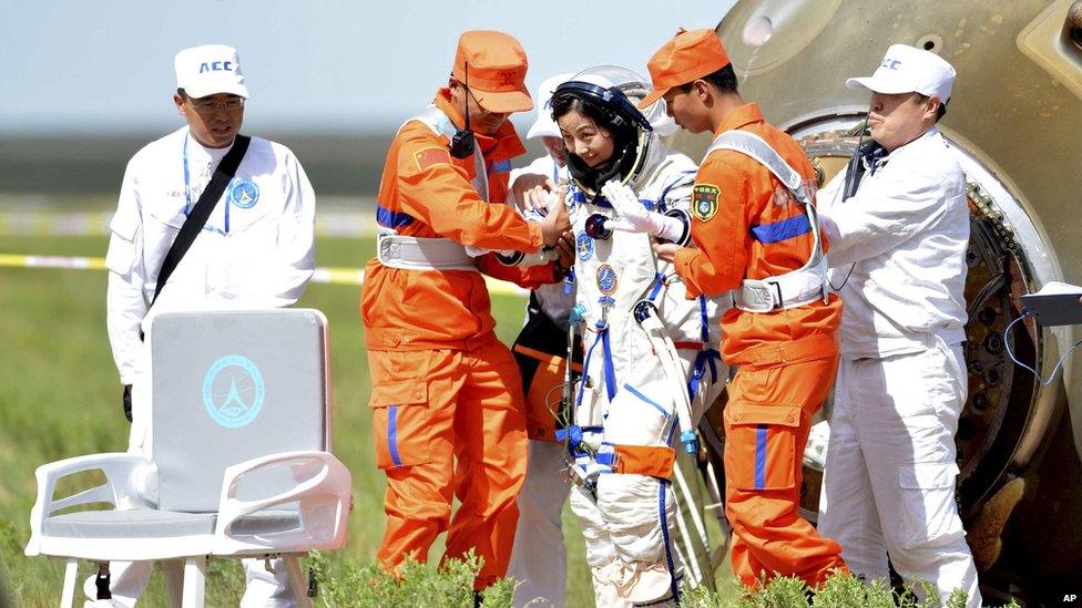 Chinese astronaut Wang Yaping exits the re-entry capsule after landing on 26 June 2013