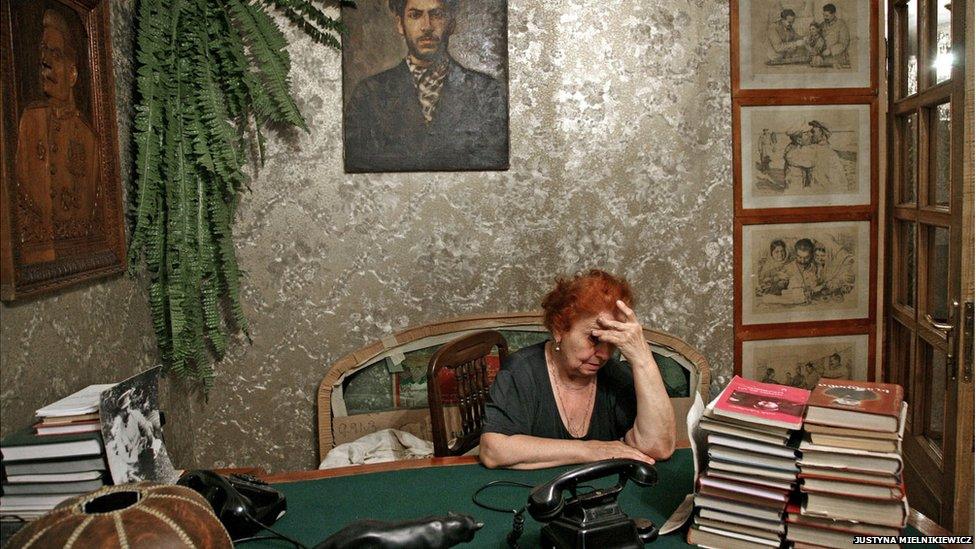 Interior of a room with Stalin memorabilia including paintings and books.
