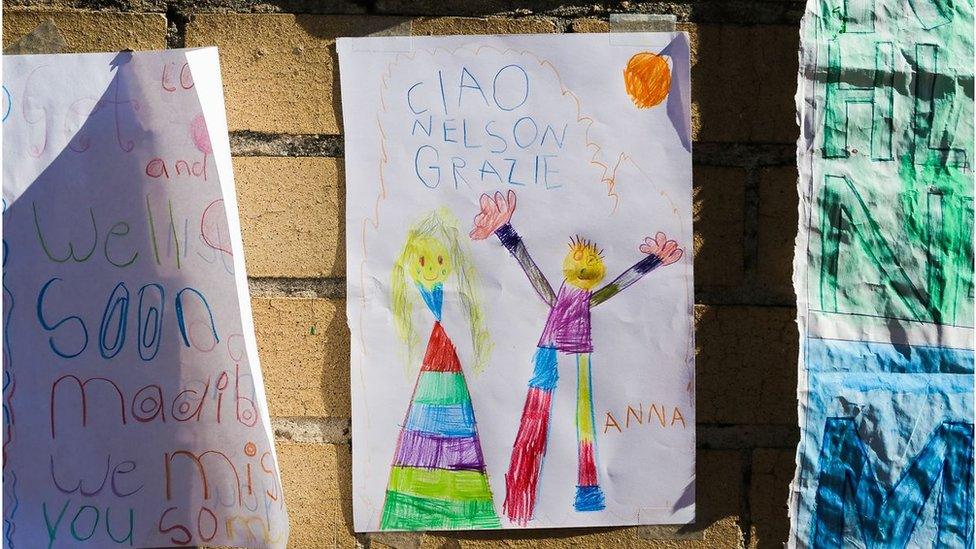 A young child's poster in coloured crayon reads: "Ciao Nelson Grazie"