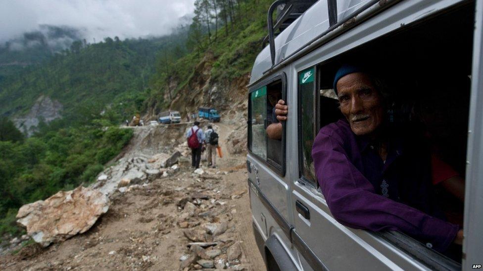 A man looks out as he drives past a damaged section of road between the town of Rudraprayag and Gauchar, Uttarakhand