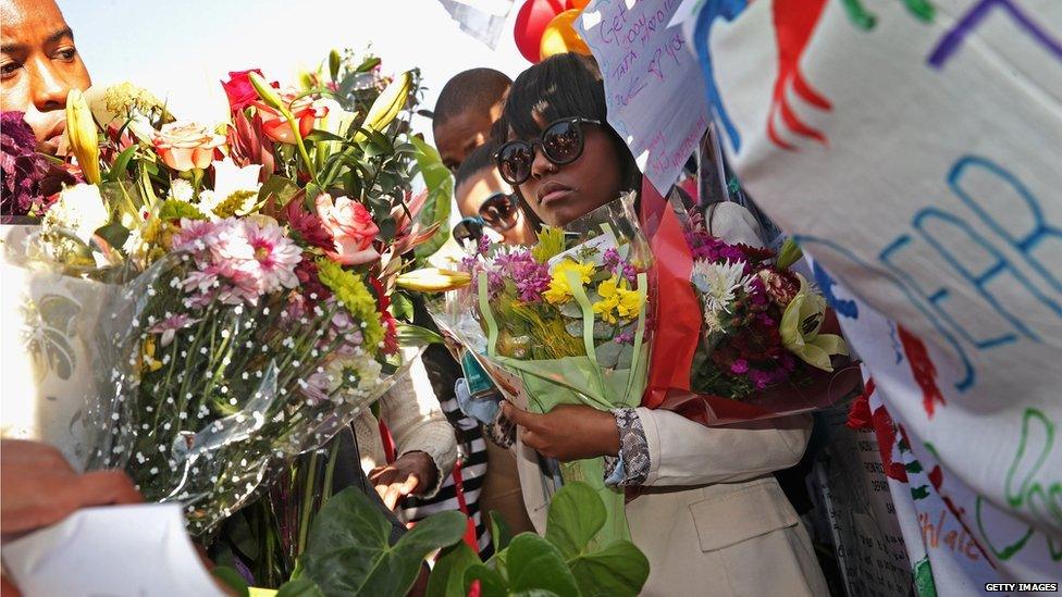 Mr Mandela's relatives hold flower bouquets (27 June 2013)