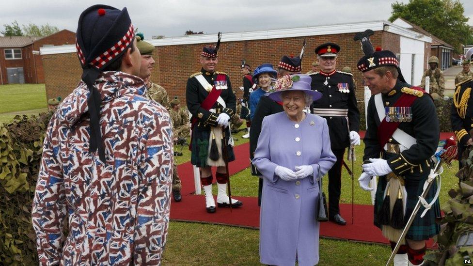 Lt Alan Garrett stands to attention in his Union Jack Onesie as the Queen looks on