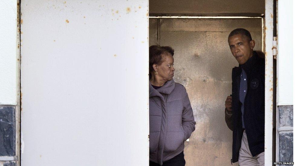 President Obama and his mother-in-law Marian Robinson look through a door during a tour of Robben Island where South-African anti-apartheid activist Nelson Mandela was held for 18 years