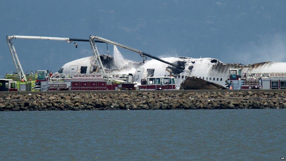 A fire engine sprays water on Asiana Flight 214 after it crashed at San Francisco International Airport on Saturday