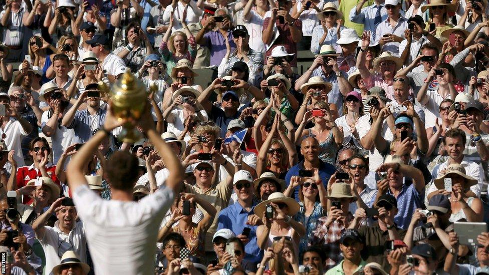 Andy Murray shows the crowd the trophy