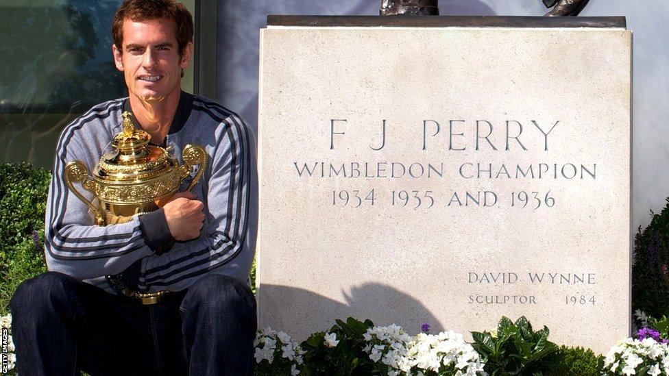 Andy Murray poses with trophy at Fred Perry statue