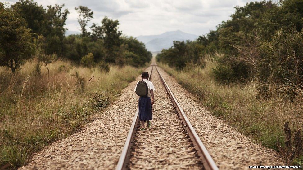 Tanzanian schoolgirl Sylvia walking along a railway