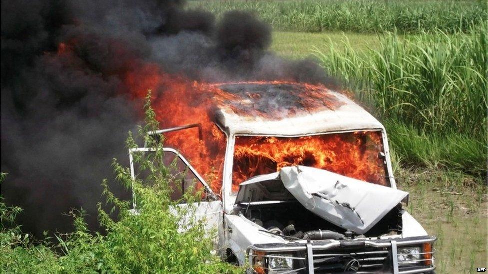 A police vehicle on fire in a field in the Saran district of Bihar state on 17 July 2013