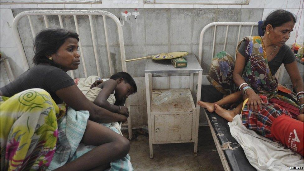 Two women sit with their sick children in a hospital in Patna on 17 July 2013