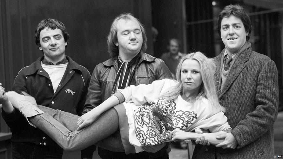 (l-r) Rowan Atkinson, Mel Smith, and Griff Rhys Jones carrying Pamela Stephenson.