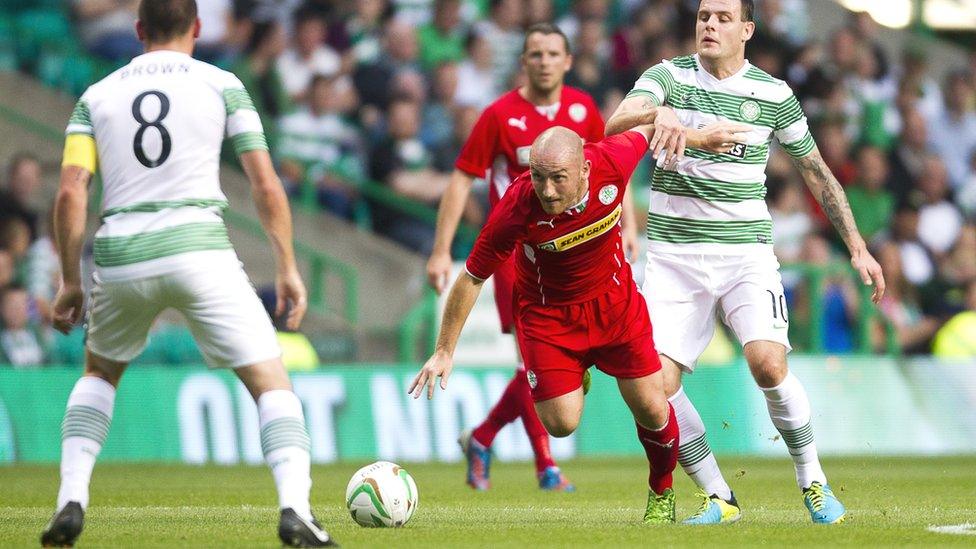 Cliftonville midfielder Barry Johnston moves clear of Celtic forward Anthony Stokes