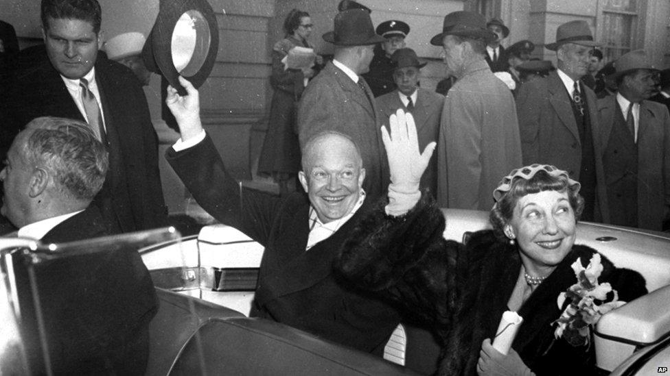 President Dwight D Eisenhower and the country's new first lady, Mamie, wave to spectators from an open car as they leave the Capitol at the start of the inauguration parade, 20 January 1953