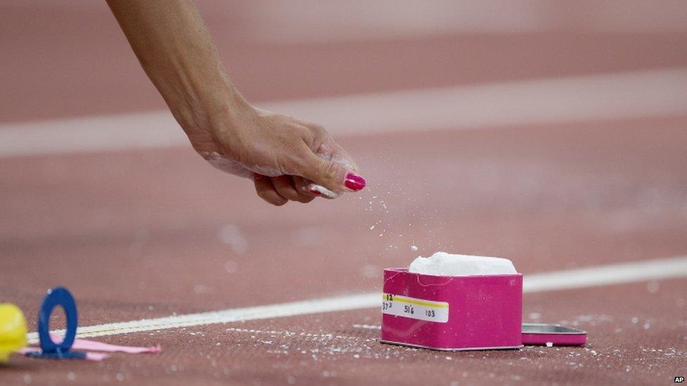 America's Jennifer Suhr grabs chalk in preparation for a pole vault