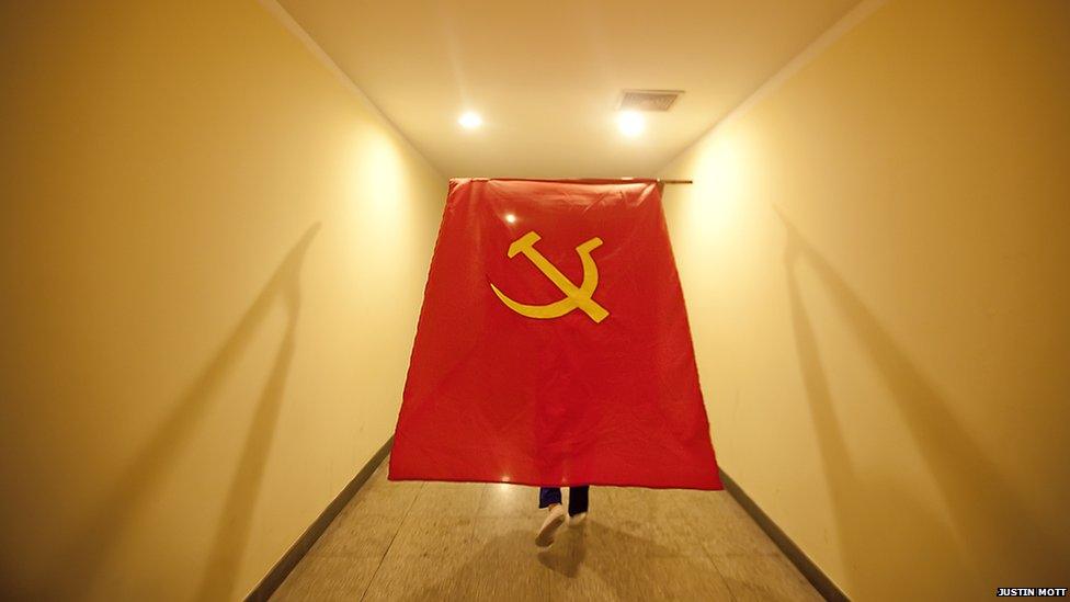 A large communist flag being carried along a corridor by a participant at Vietnam's 11th party congress