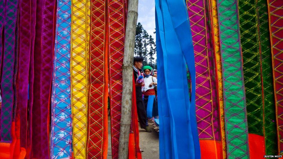 A traditional clothing vendor at a Sunday market in Ha Giang Province, Vietnam. This remote province borders China and offers beautiful landscapes and a view into remote ethnic minority villages.