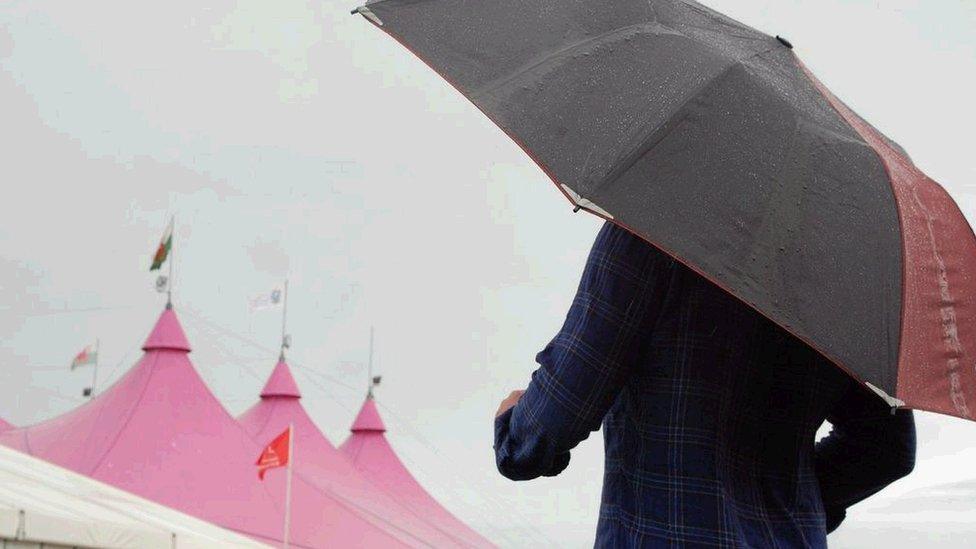 Daeth y glaw i'r Maes amser cinio dydd Sul, gyda llawer o bobl yn chwilio am loches yn y Pafiliwn / The rain came on Sunday and people sought shelter in the Pavilion