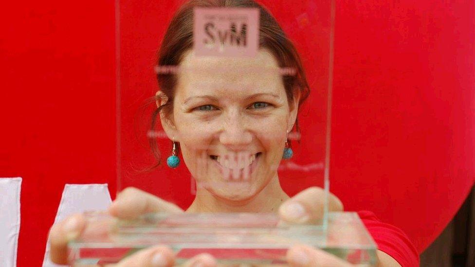 Laura Karadog, Swyddog Addysg Oxfam, gyda thlws Sefydliad y Merched am y stondin orau ar y Maes / Laura Karadog, Oxfam's education officer, with the Women's Institute trophy for best stall at the Eisteddfod