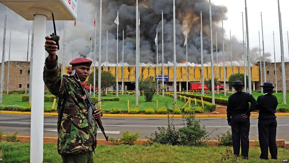 A General Service (GSU) officer gestures outside the burning Jomo Kenyatta international airport on 7 August 2013.