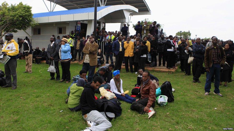 Stranded passengers and onlookers gather after a fire disrupted all operations at the Jomo Kenyatta International Airport in Kenya"s capital Nairobi 7 August 2013.