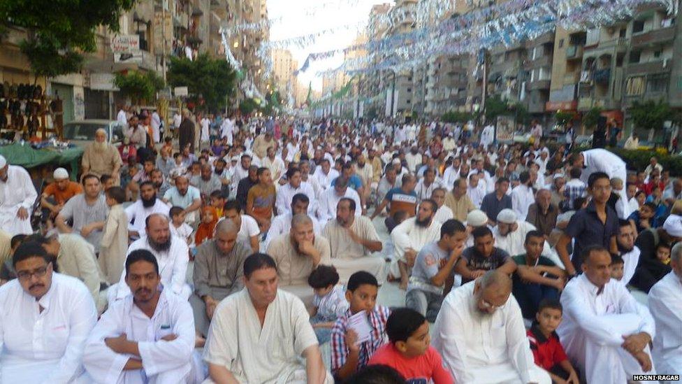 Men sat gathered in the streets for Eid prayers in Egypt. Photo: Hosni Ragab