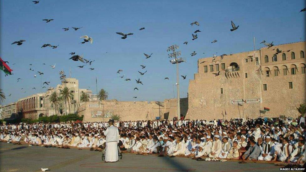 Men sit in square during Eid prayers in Libya. Photo: Magdi Altajory