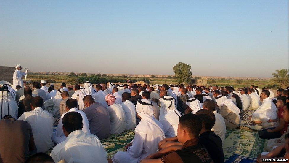 Men are led in prayer in Tikrit, Iraq. Photo: Nazer Al Mobidy