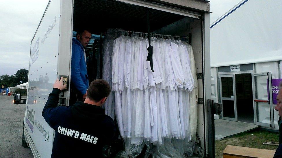 Gwisgoedd Gorsedd y Beirdd yn cael eu cludo o'r Maes i gael eu golchi a'u cadw yn stordy'r Eisteddfod / The Gorsedd of the Bards wardrobe being carted off for another year