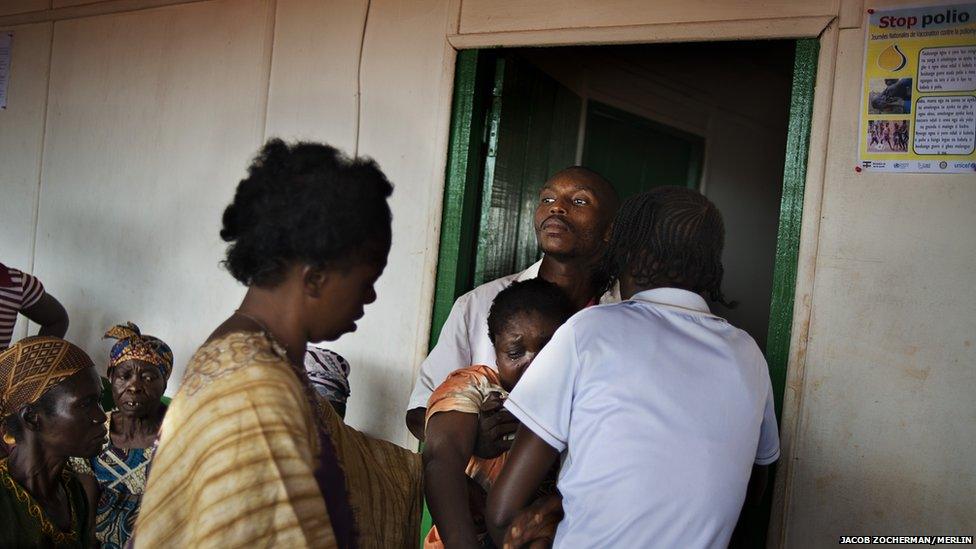 Nurse Anatole Nzu attending to a patient who has just collapsed at the Merlin-supported hospital in Batalimo refugee camp, Central African Republic