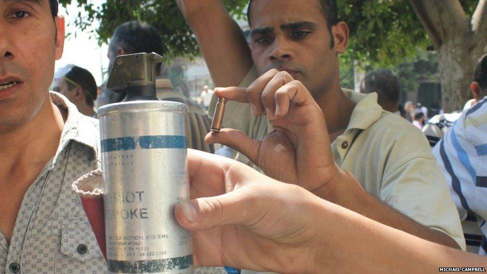 Protesters display the military weapons they are up against; tear gas and bullets