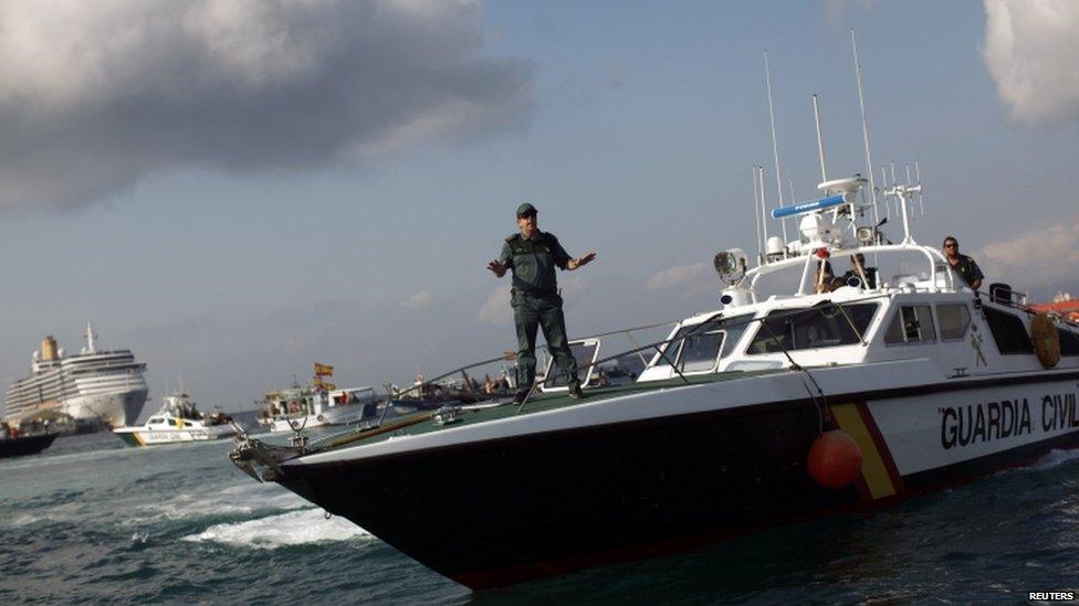 A member of the Spanish Civil Guard tries to calm down a Spanish fisherman (not pictured) in his fishing boat taking part in a protest