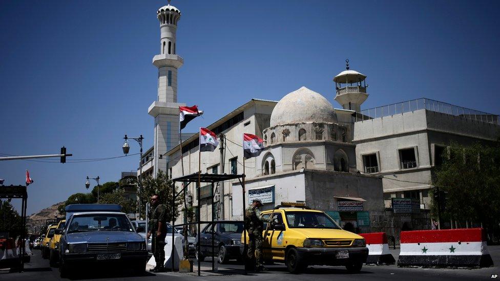 Syrian security forces check ID documents at a checkpoint on Baghdad Street, Damascus (21 August 2013)