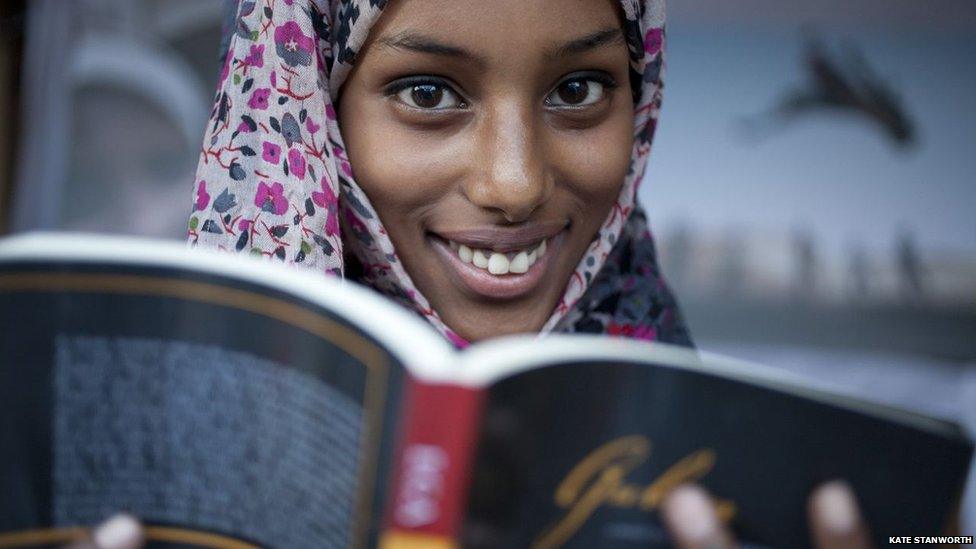 A book fair volunteer, Sumaya, reading Guban by New York writer Abdi Latif Ega - Hargeisa, Somaliland