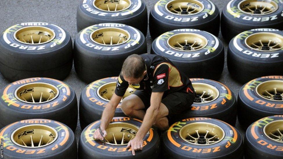 A man marks tyres in pit lane