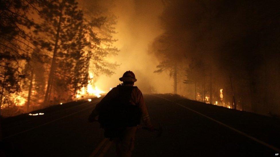 A firefighter walks down Highway 120 while fighting Rim Fire in California on 25 August 2013