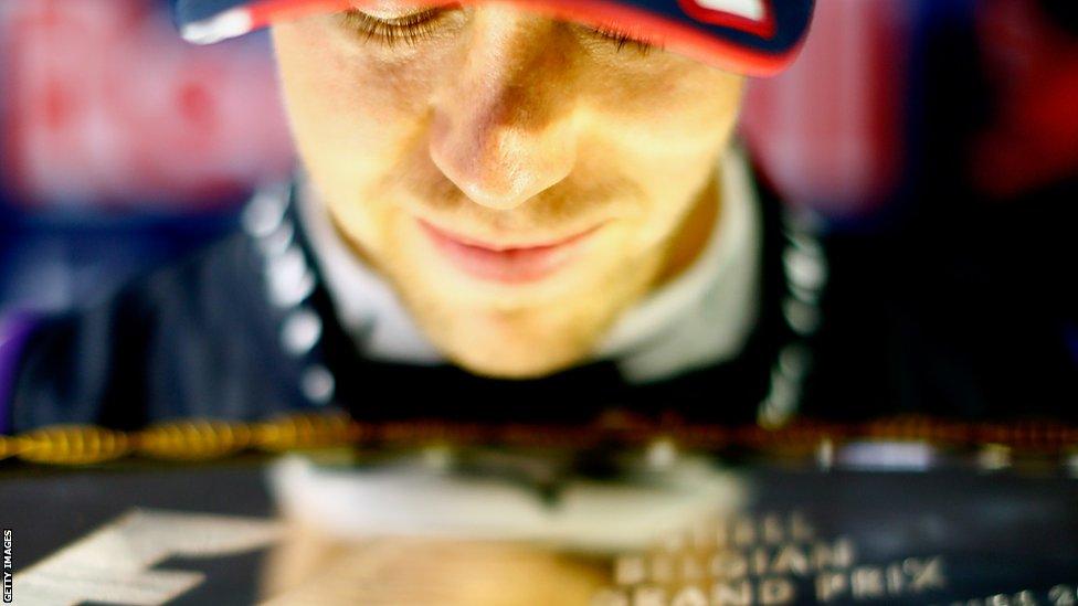 Sebastian Vettel celebrates in his team garage with the winners' trophy