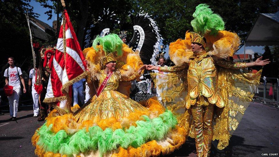 A man and a woman wearing matching gold outfits