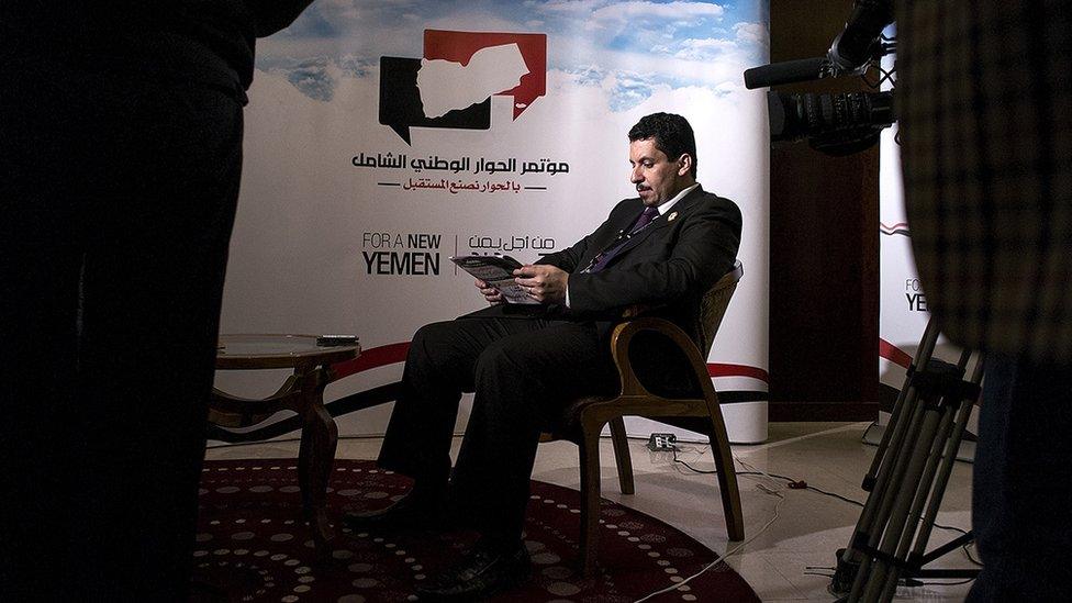 NDC Secretary General Ahmed Awad bin Mubarak reads a newspaper before a television interview