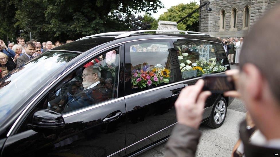 People watch the coffin of Irish poet Seamus Heaney leave the Church of the Sacred Heart in Donnybrook, Dublin, Ireland. Heaney will be buried in his native Bellaghy, in County Londonderry.