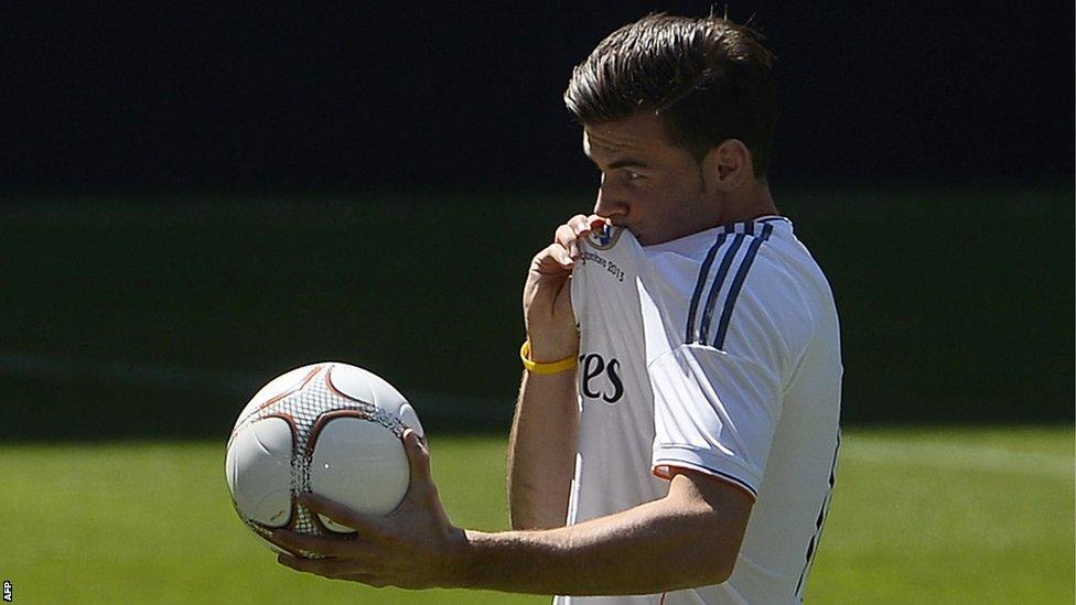 Gareth Bale kisses the Real Madrid badge