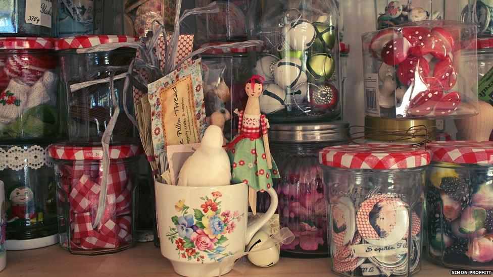 Close-up of jam jars of textiles, fabric scraps, baubles and badges in Sophie Tilley's studio